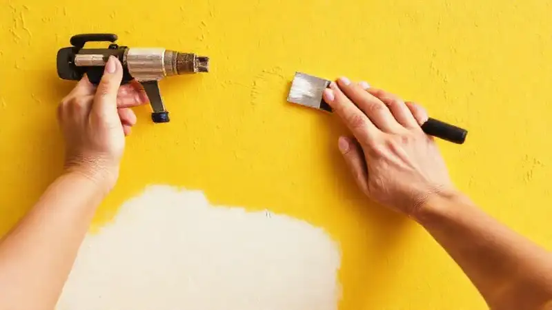 Pintores preparan una pared amarilla impecable