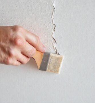 Manos reparan la pared con calma