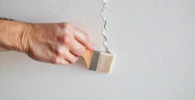 Manos reparan la pared con calma