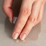Una mano aplica cinta en reflejo