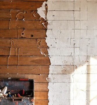 Un pintor frustrado arregla una pared deteriorada