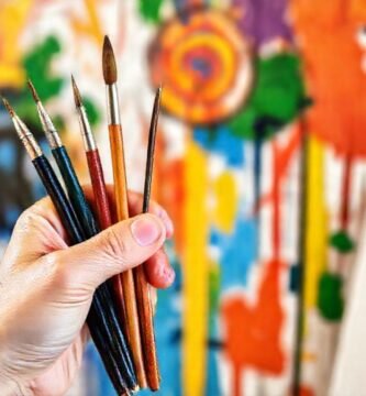 Manos pintan mural vibrante y feliz