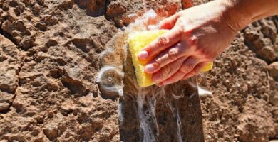 Mano limpia piedra con agua